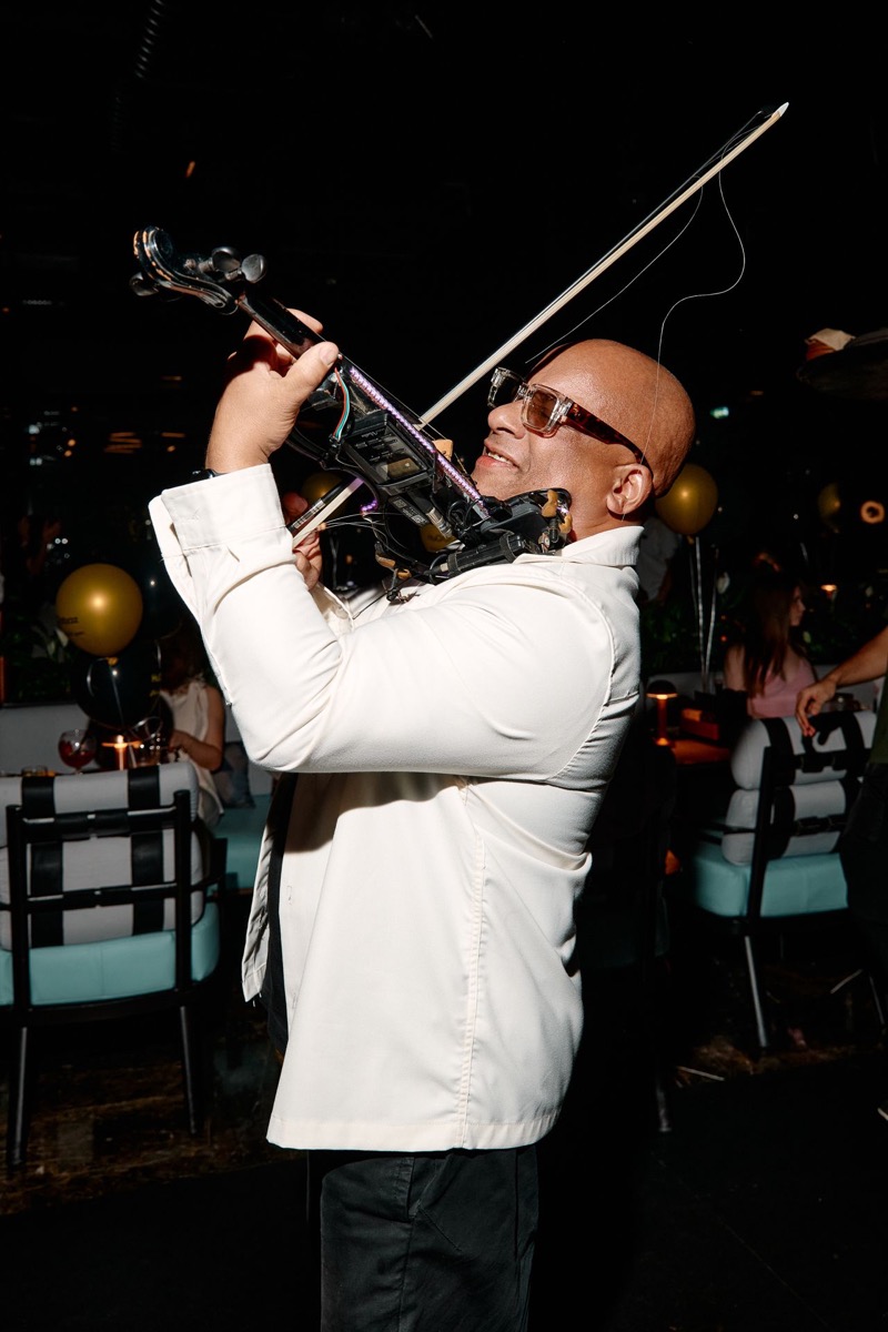 Julio Cuba playing electric violin up close at a venue
